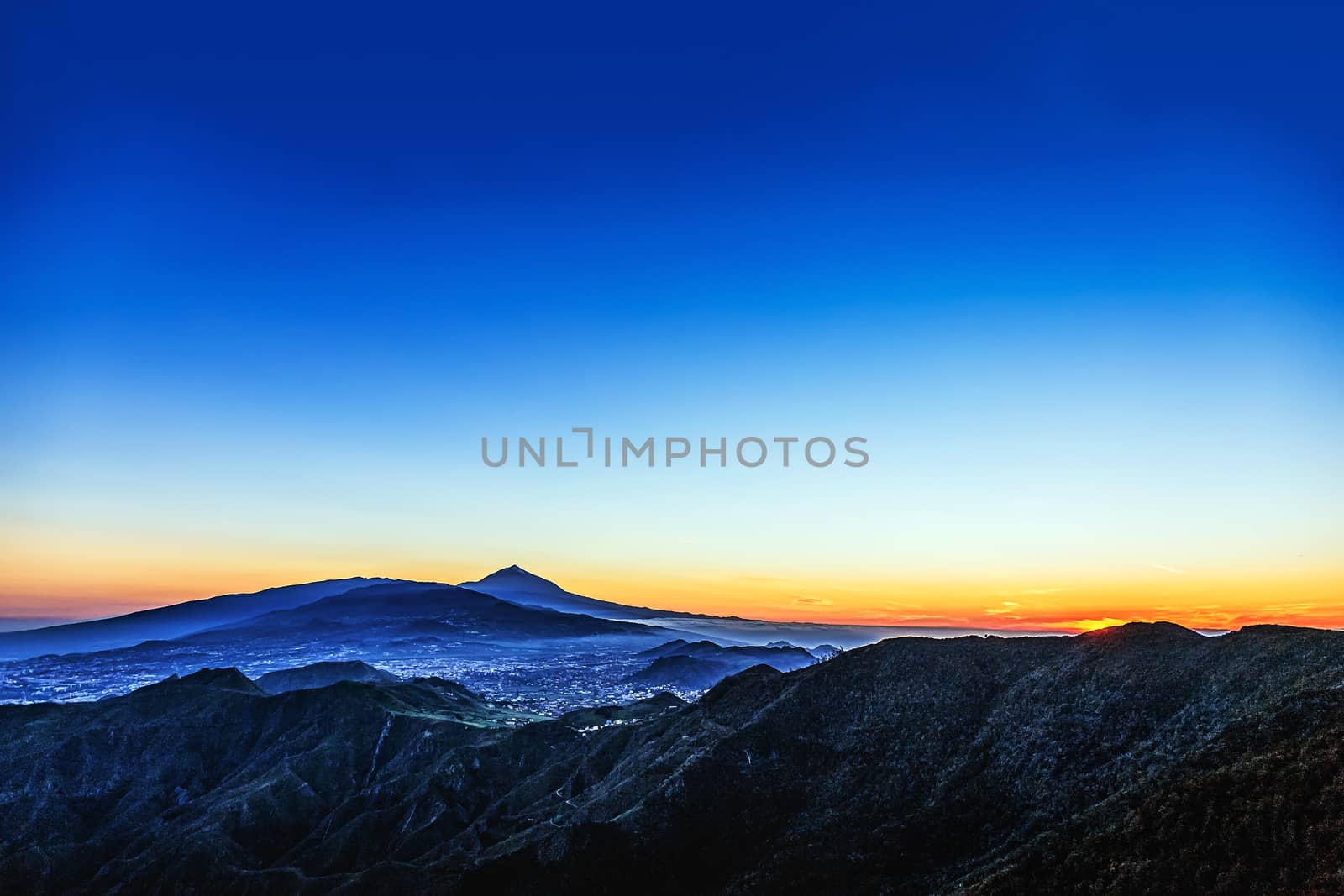 Sunset in mountains and blue sky with haze and Teide volcano on background in Tenerife Canary island, Spain