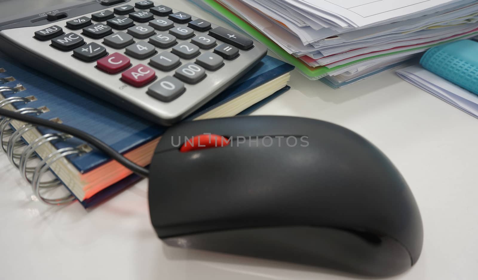 Notepad, file document and calculator placed on desk at office.                               