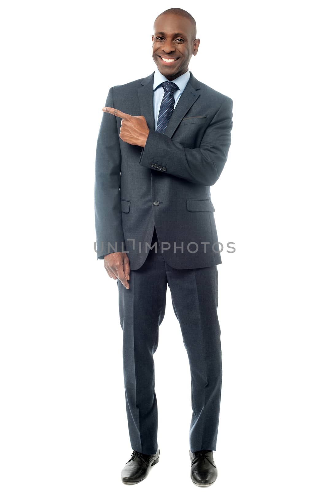 Full length of businessman pointing to copy space
