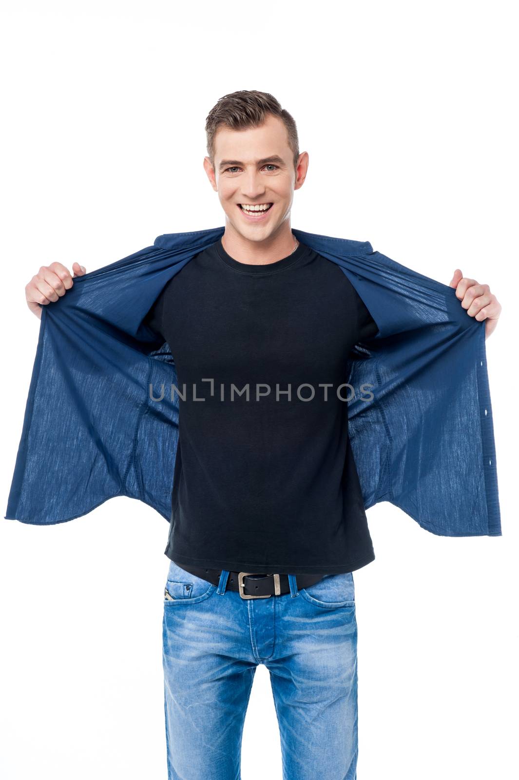 Smiling young man pulling his shirt in style