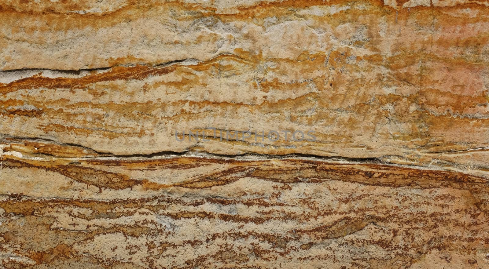 Sandstone block with bold brown and orange markings as abstract background texture
