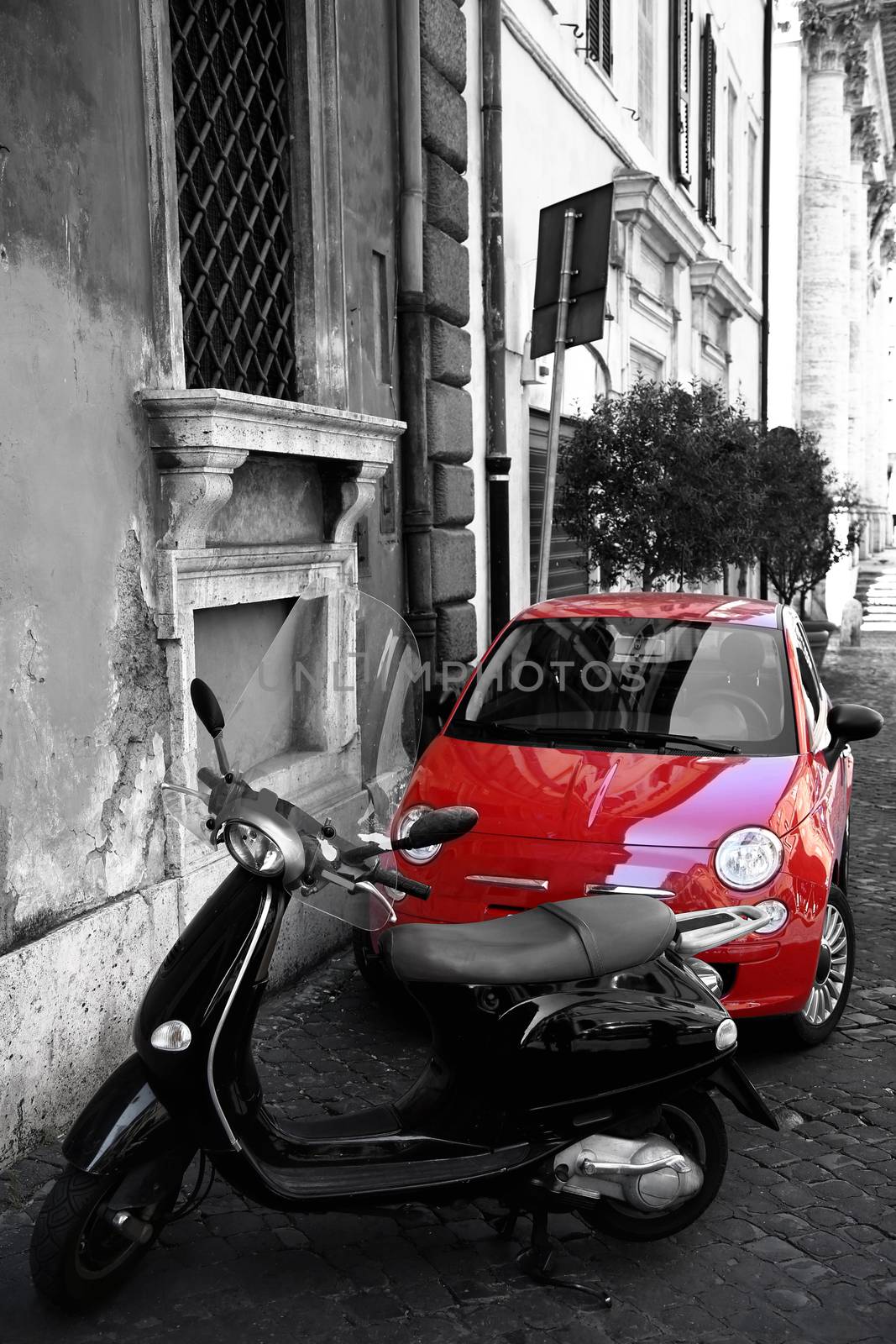 Red tiny car at the city street, Rome, Italia (black/white)