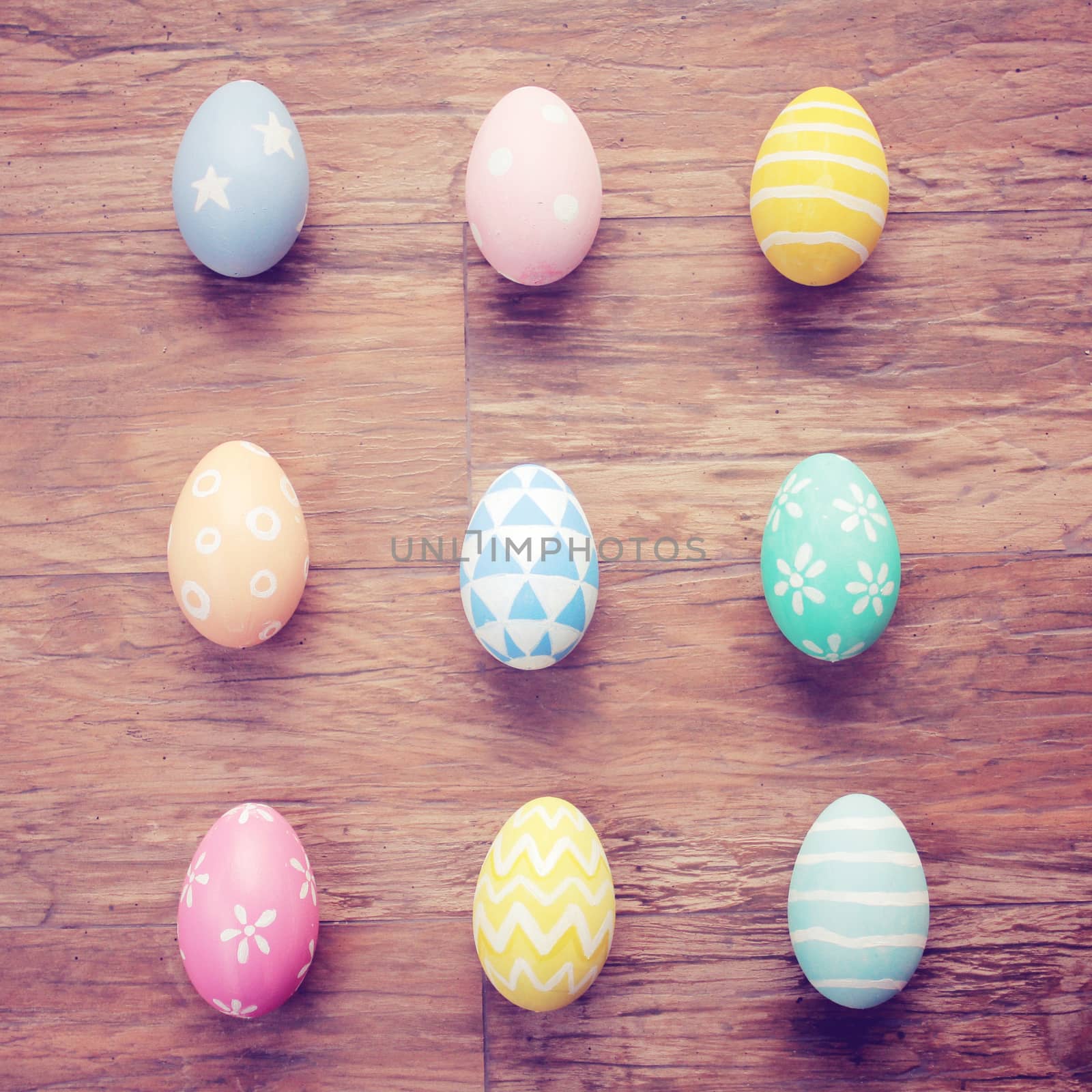 Top view of colorful easter eggs on wooden background with retro filter effect