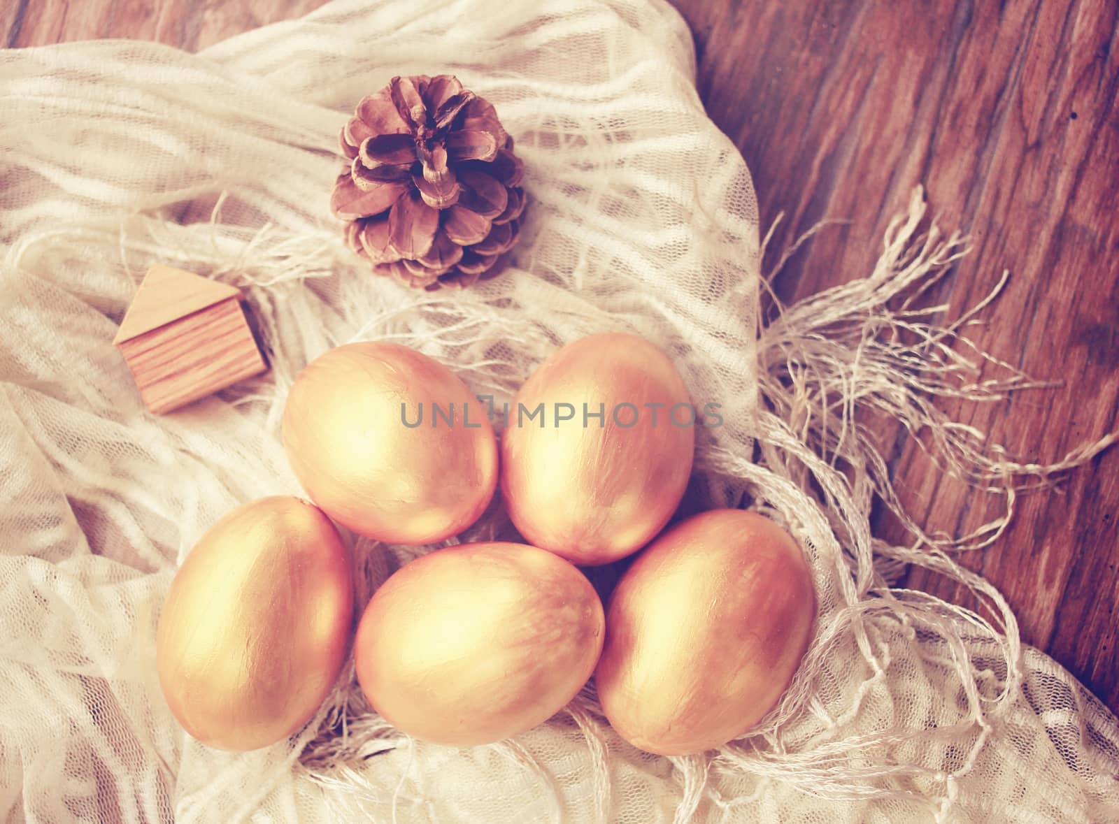 Gold easter eggs and decorated on wood background with retro filter effect