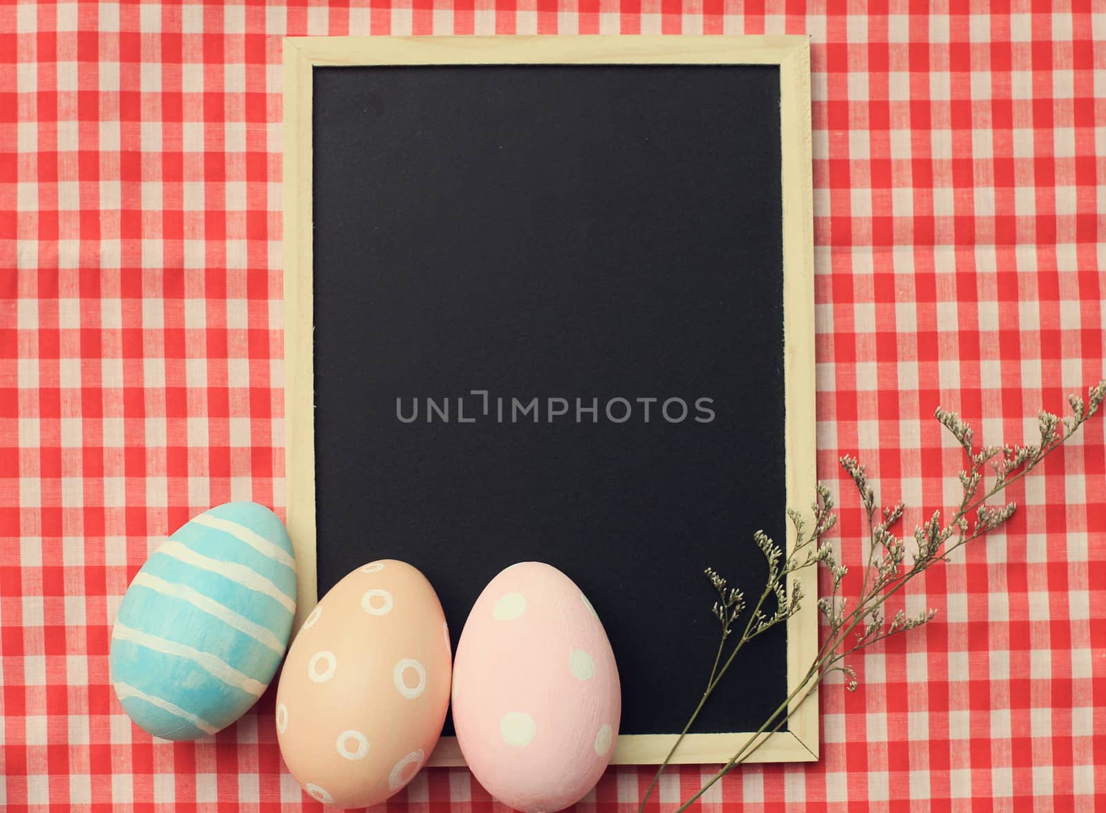 Colorful easter eggs on blank blackboard with retro filter effect