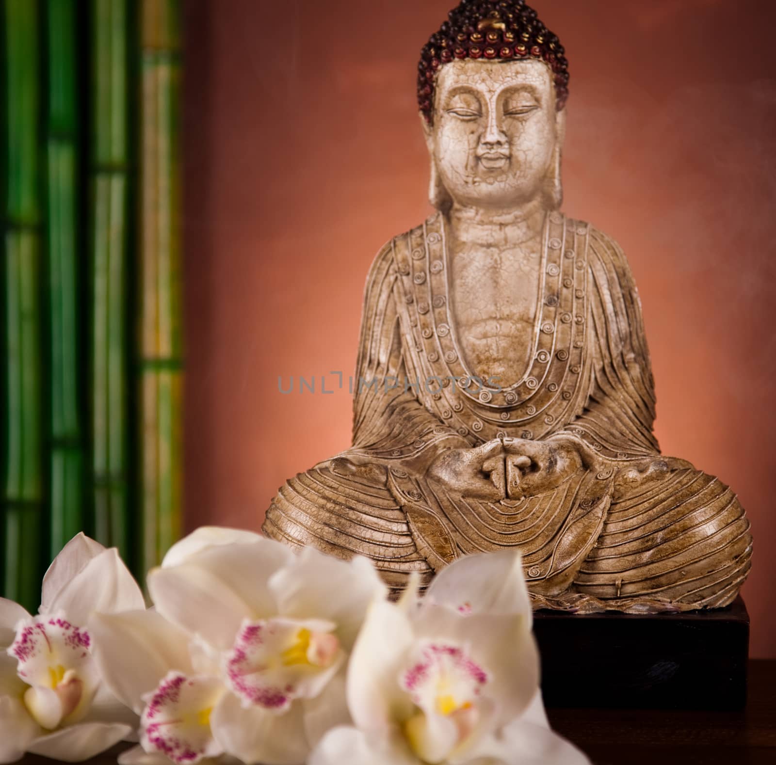 Buddha statue with orchid flower