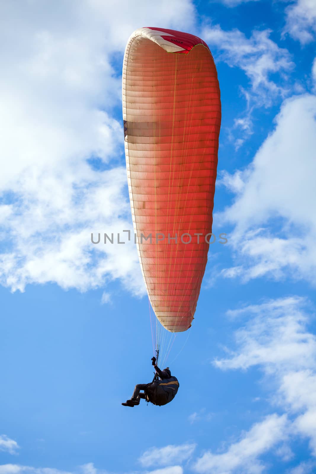 Paraglider flying on blue sky