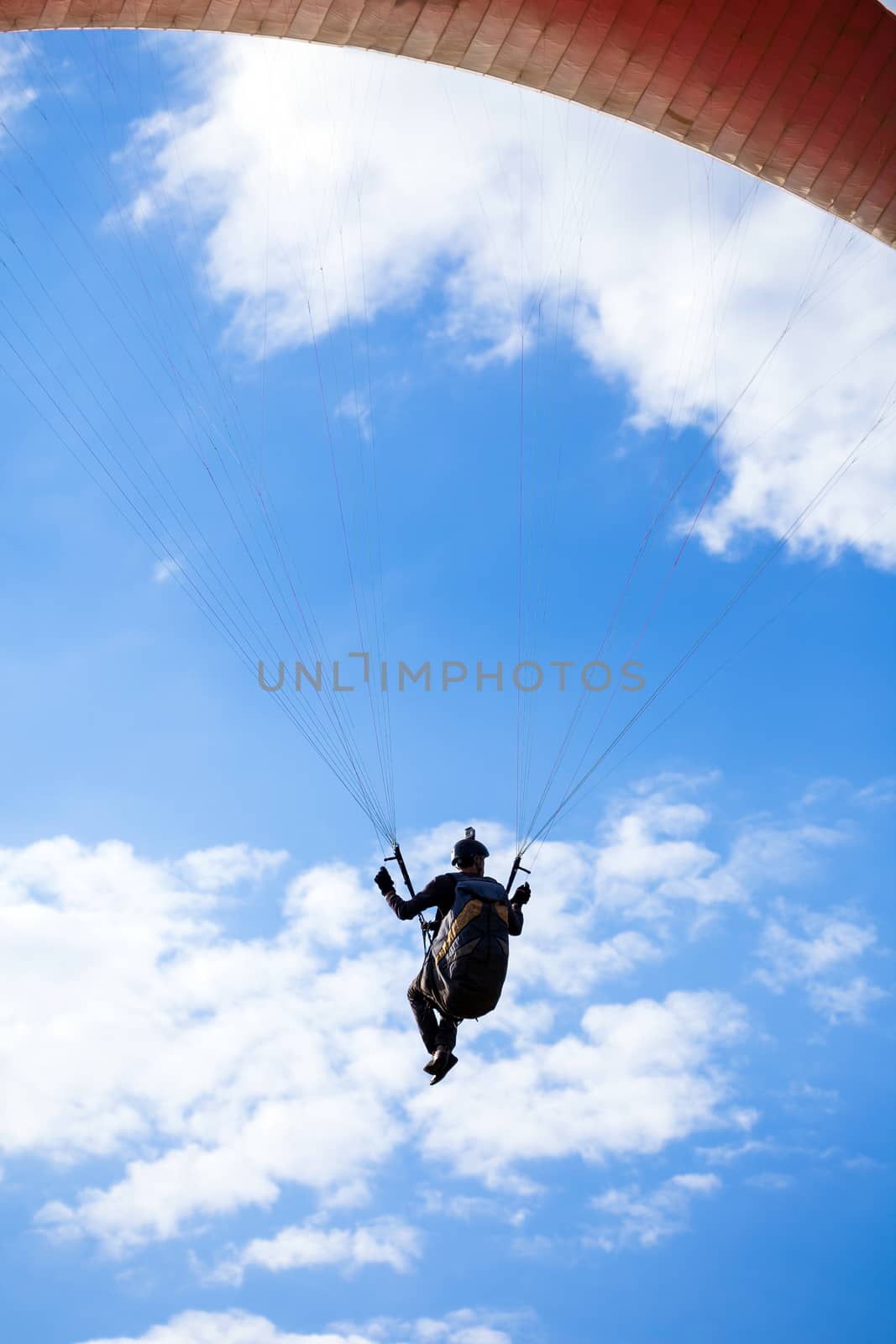 Paraglider flying on blue sky