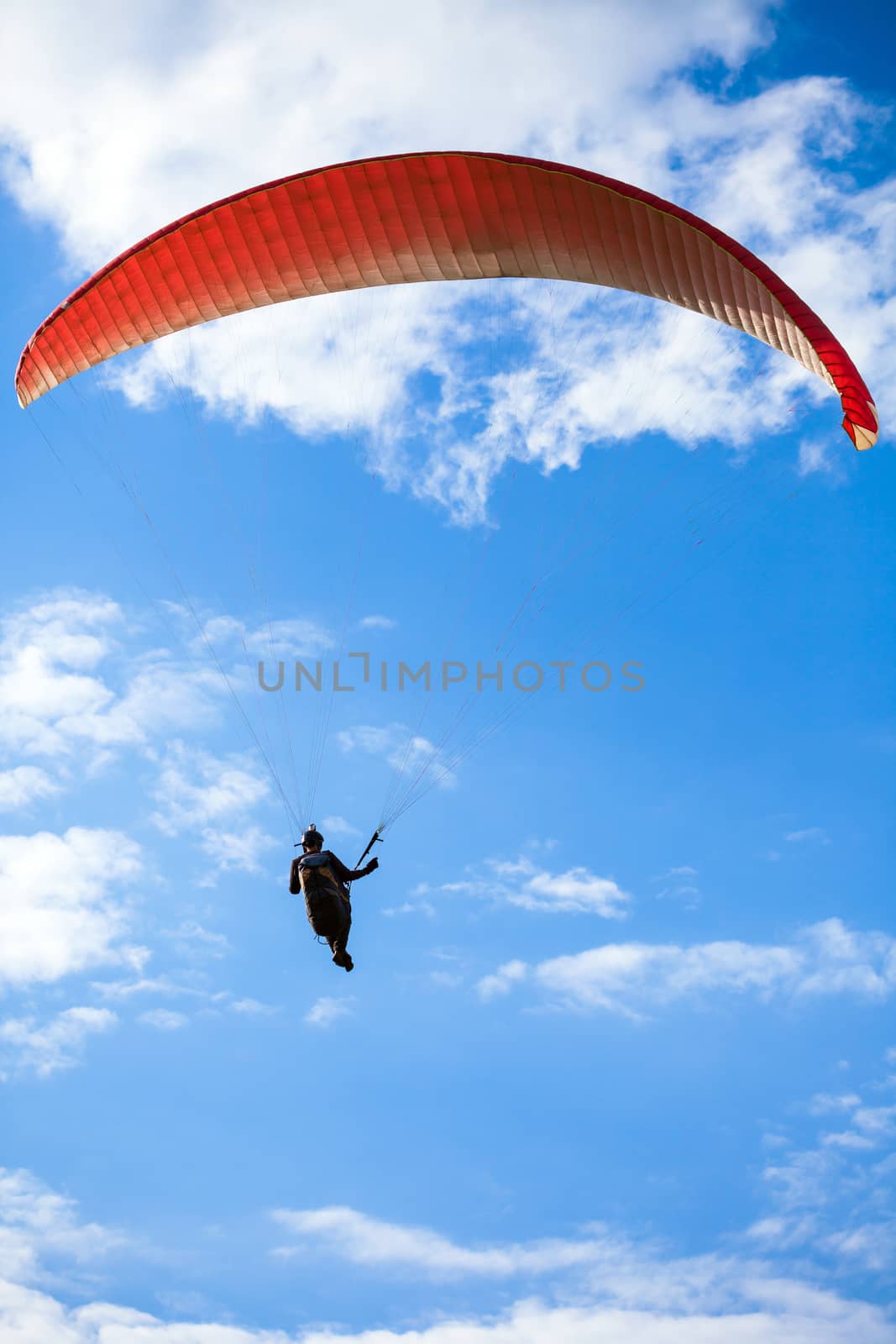 Paraglider flying on blue sky