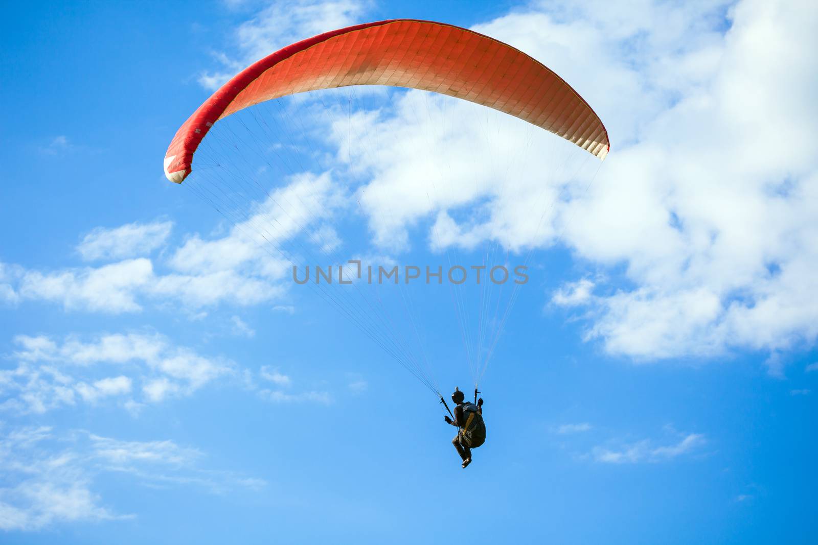 Paraglider flying on blue sky