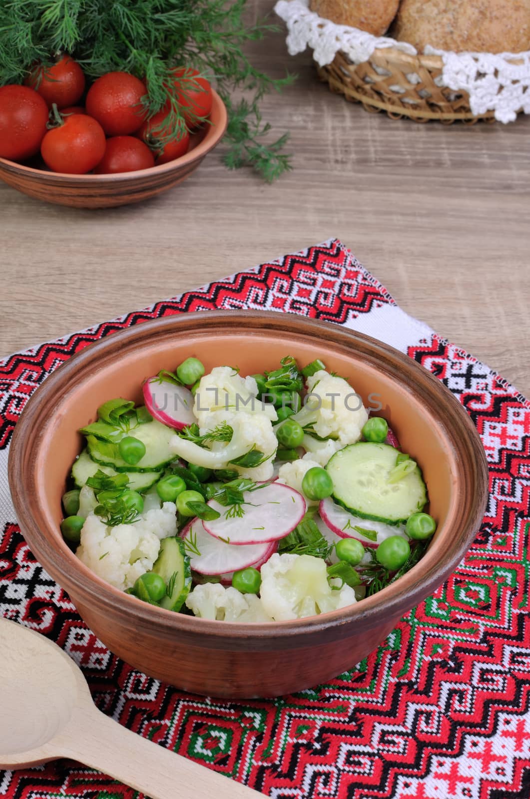 Cauliflower salad with cucumber, radish, peas and onions