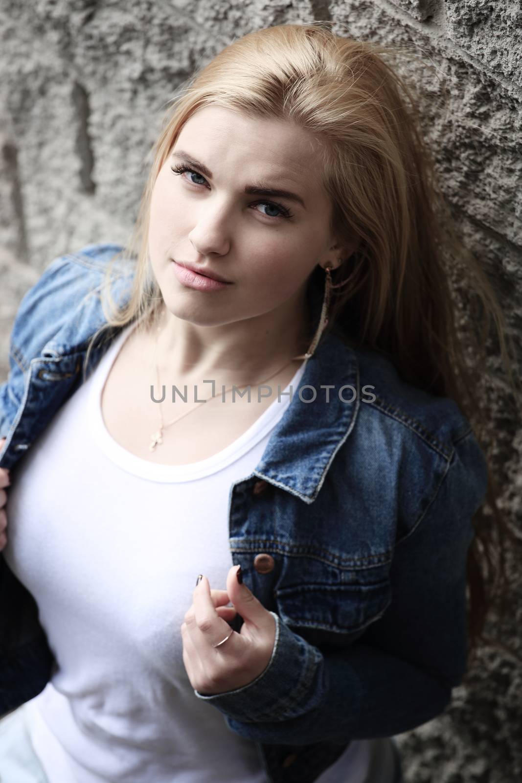 Urban style portrait of young beautiful blond woman in denim