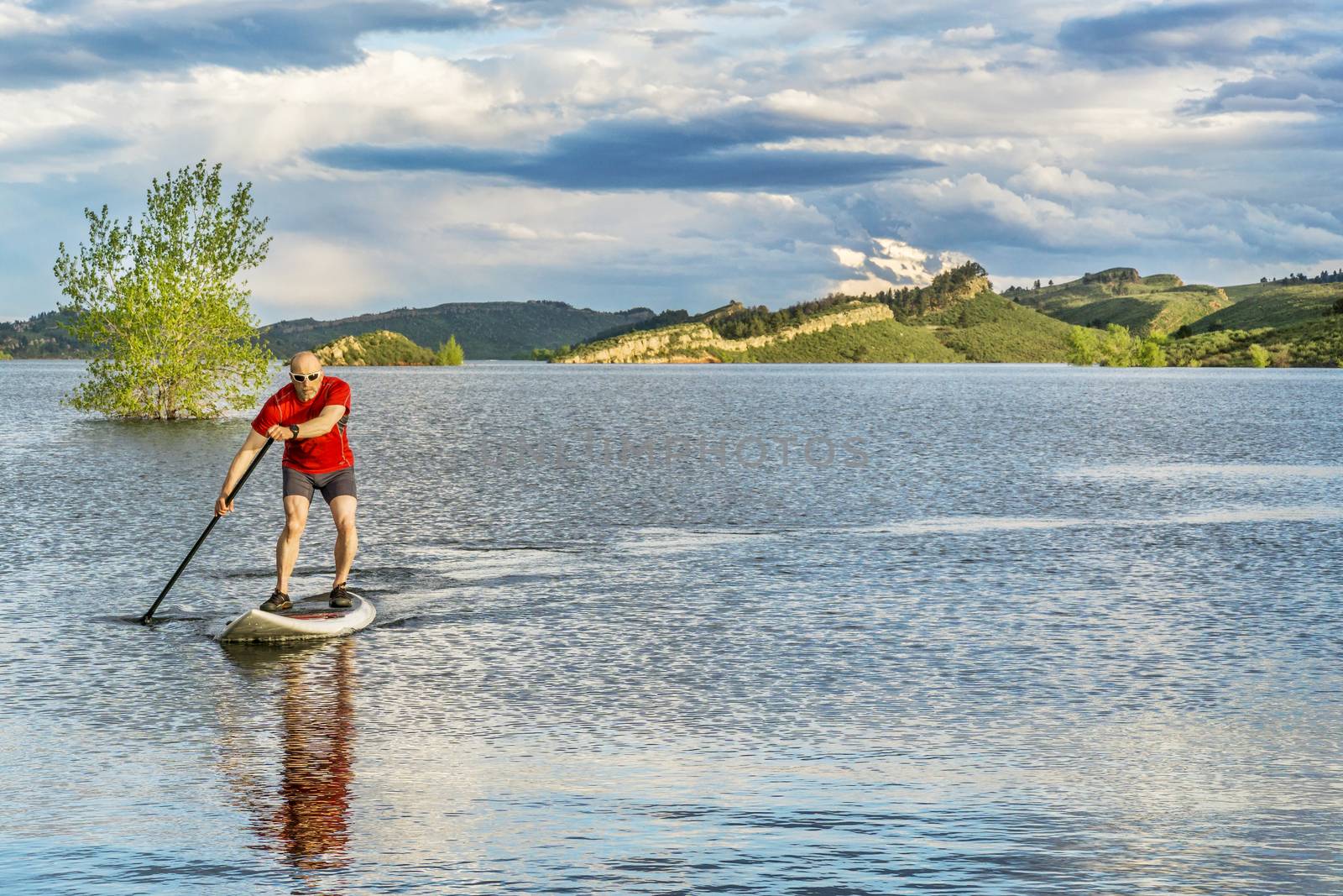 mountain lake landscape with a senior male paddling a SUP paddleboard with a copy space - Horsetooth Reservoir, Fort Collins, Colorado
