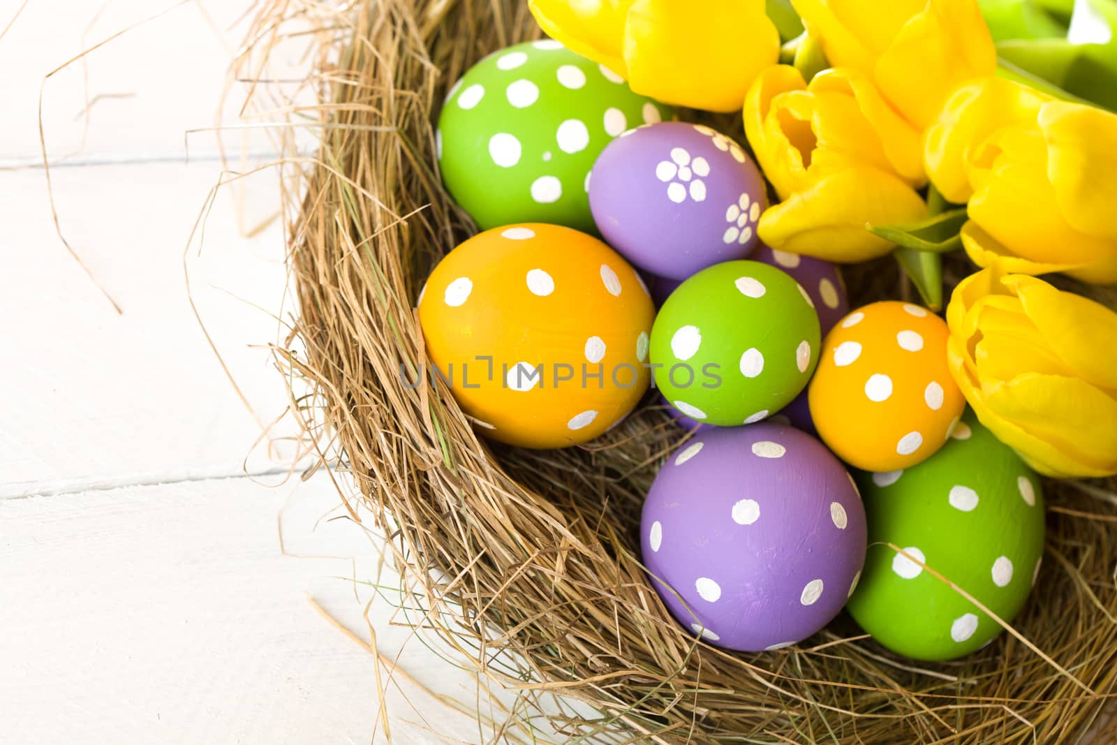 Easter eggs in the nest on rustic wooden background