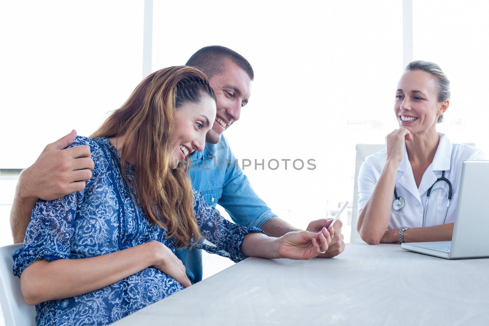 Happy couple looking at ultrasound scan of their baby in medical office