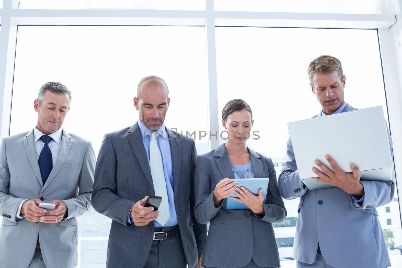 Business colleagues using their multimedia devices in the office