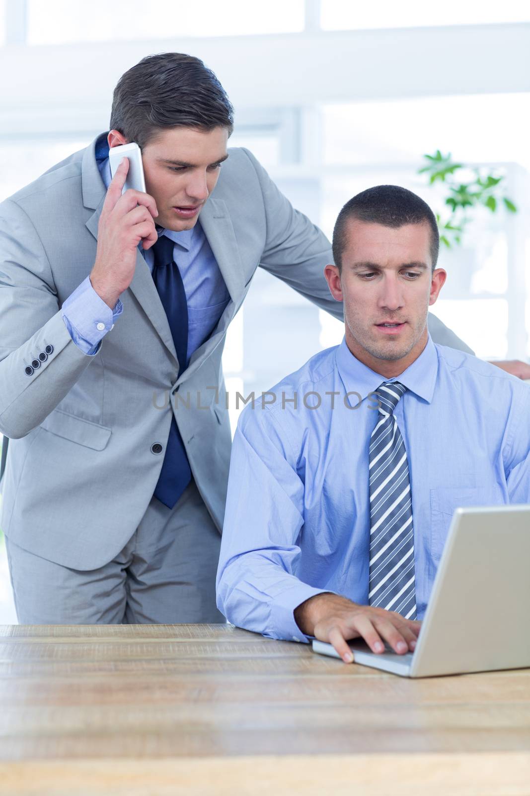 Businessmen using laptop in office
