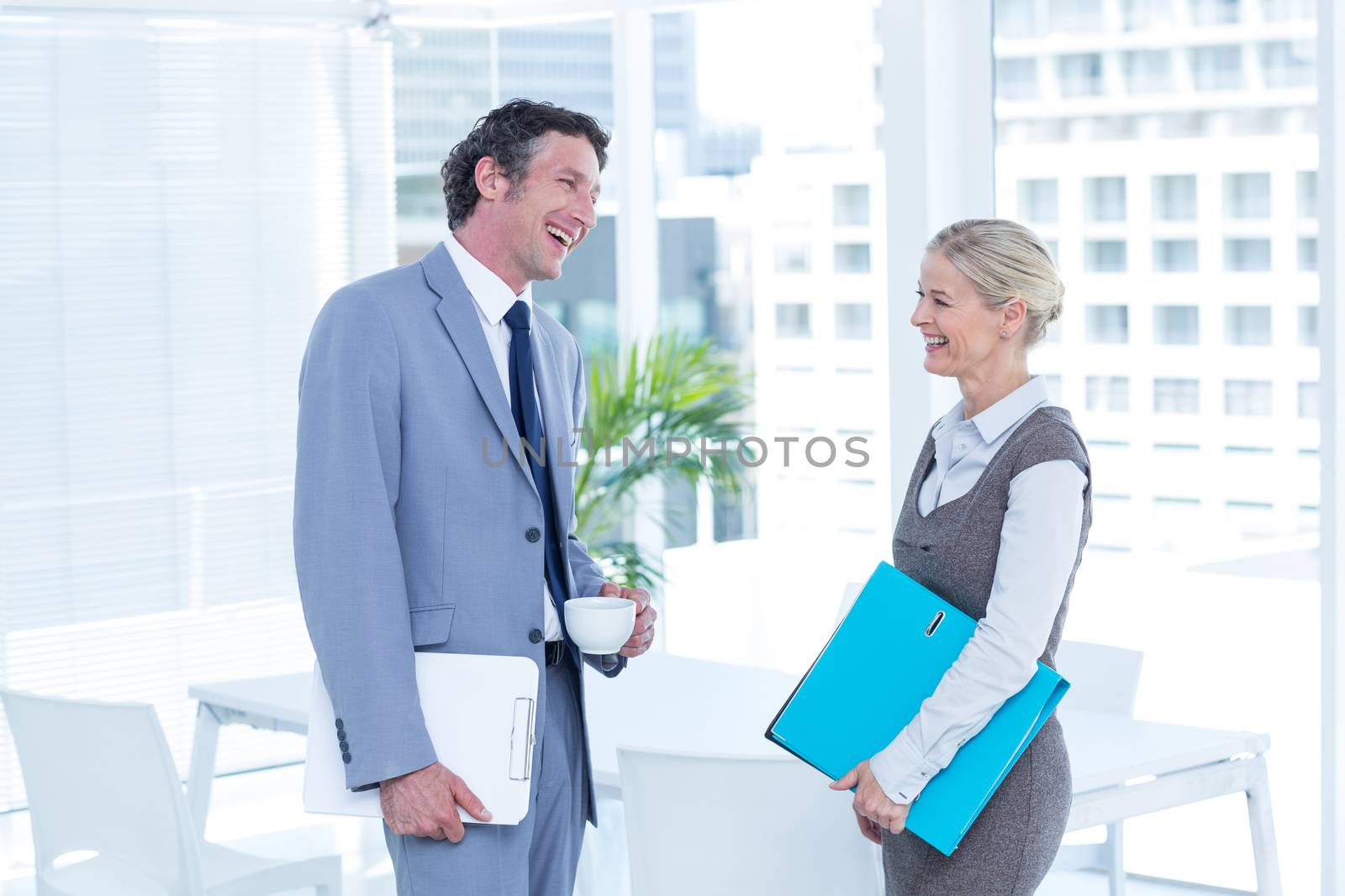 Business people laughing in an office by Wavebreakmedia