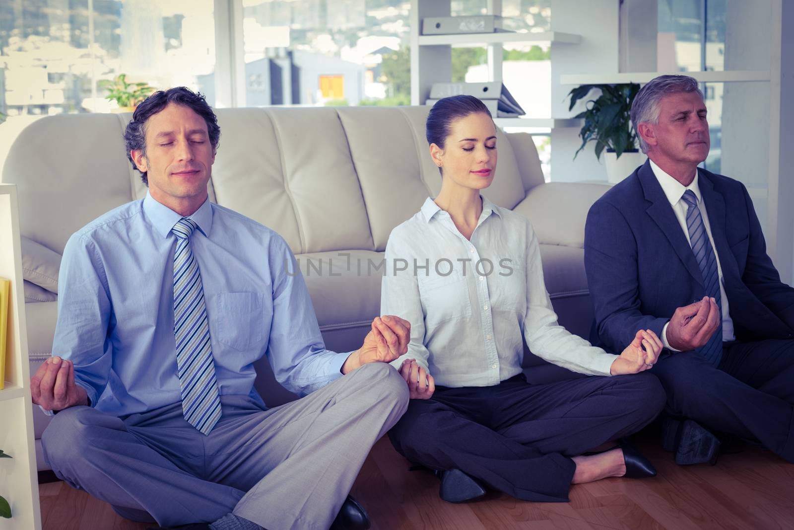 Business people meditating in lotus pose by Wavebreakmedia