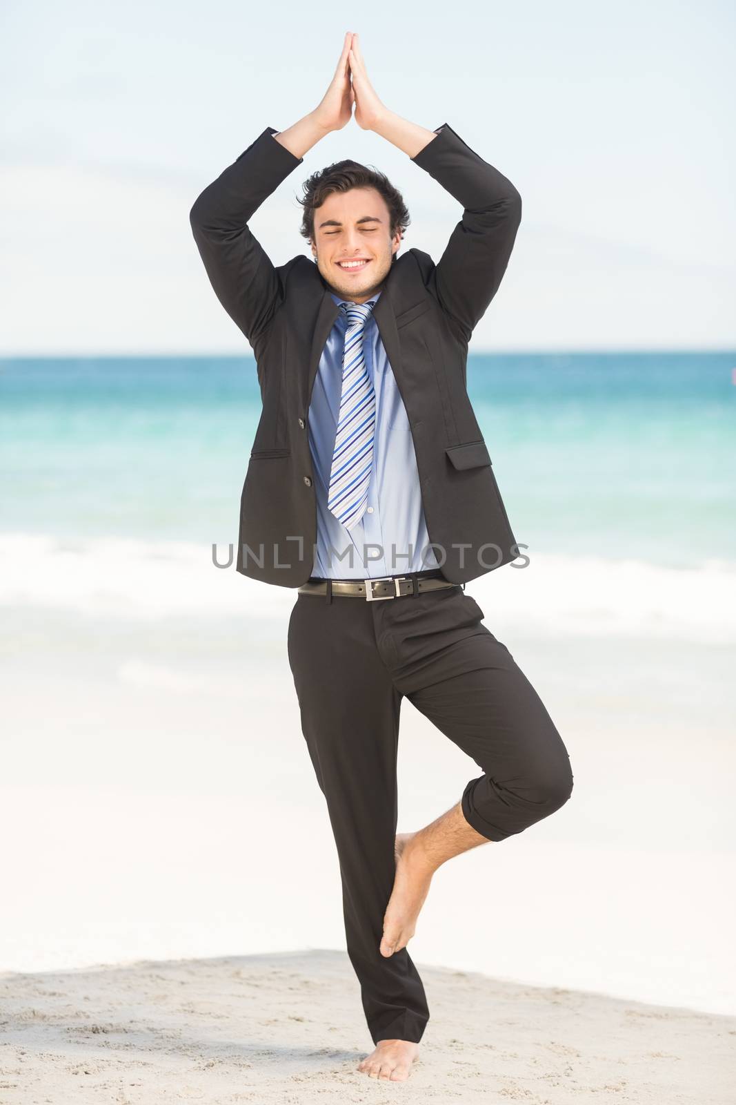Happy businessman doing yoga  by Wavebreakmedia
