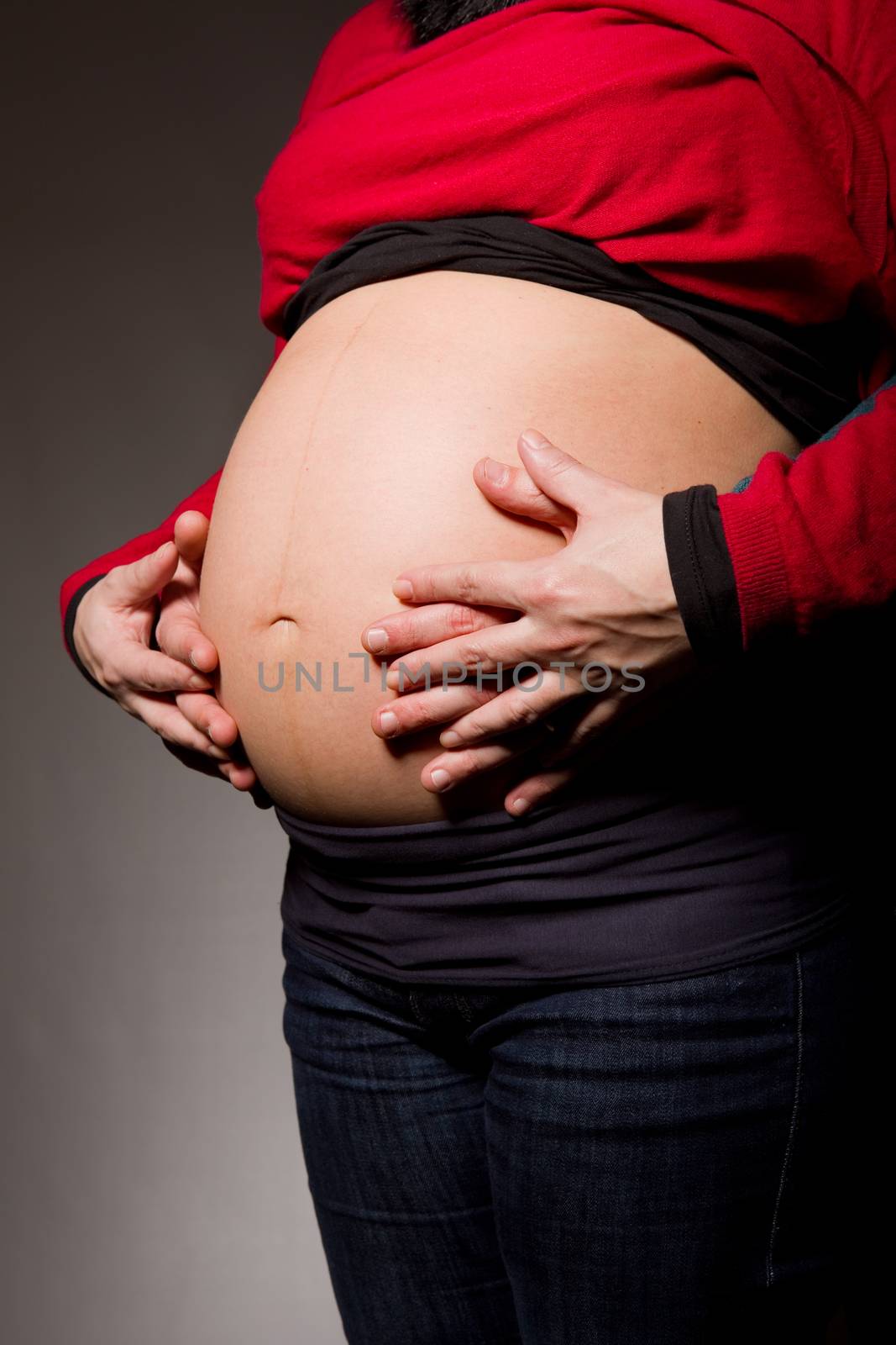 hands embrace a belly of the pregnant woman