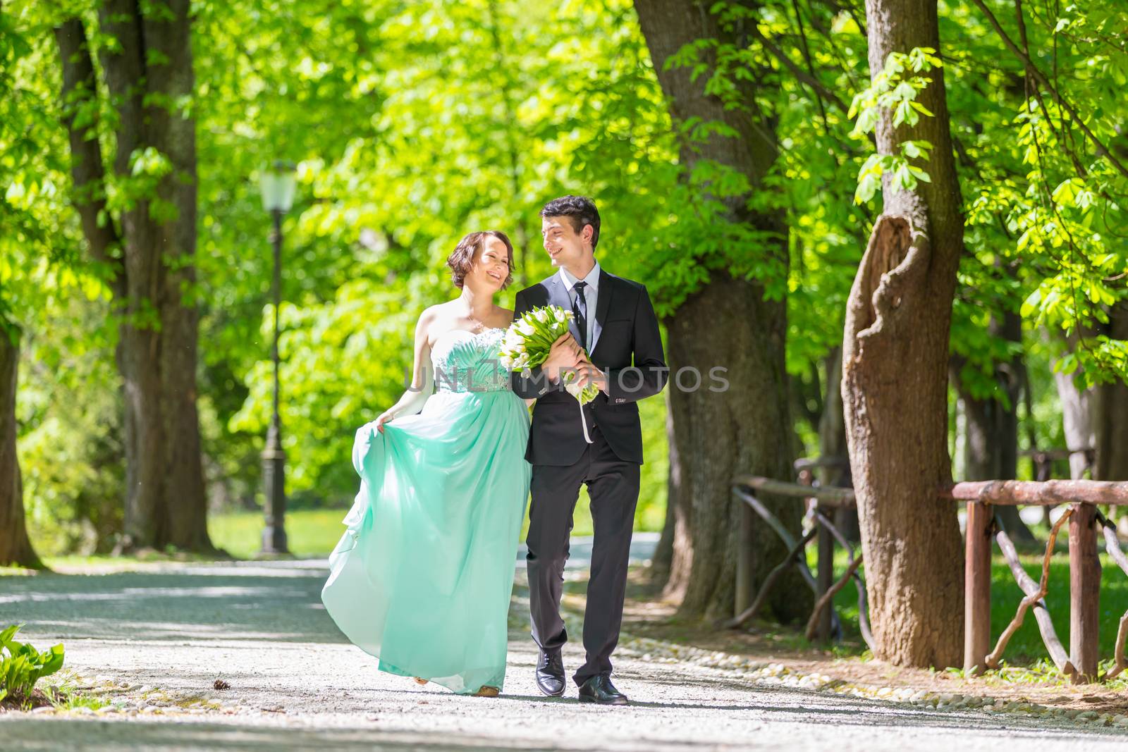 Wedding couple walking in park. by kasto