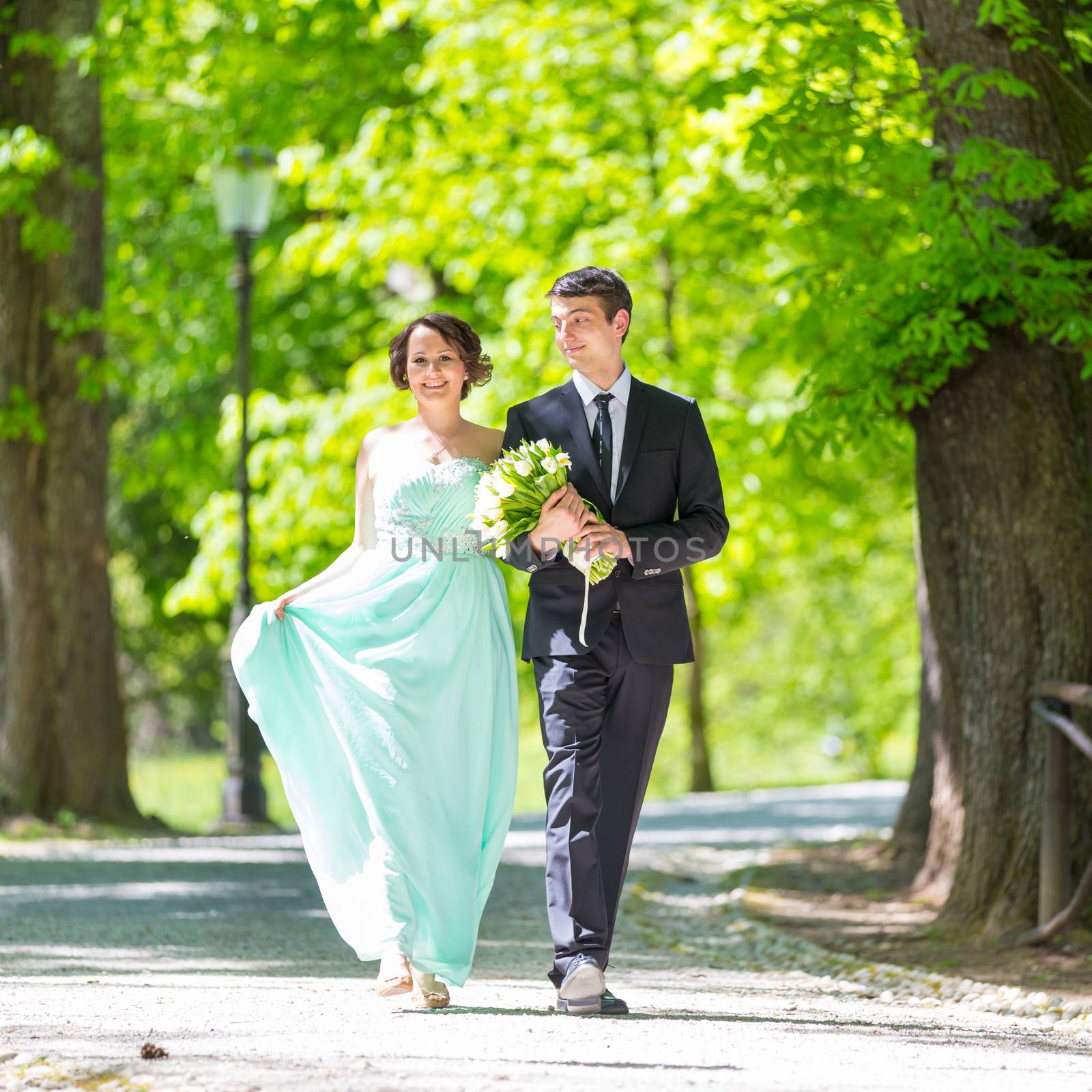 Wedding couple walking in park. by kasto