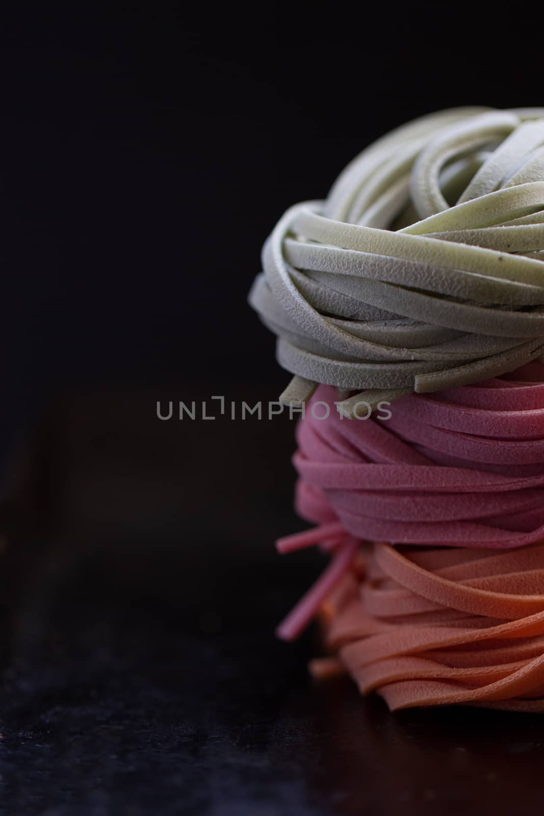 colorful pasta tagliatelle on a black background