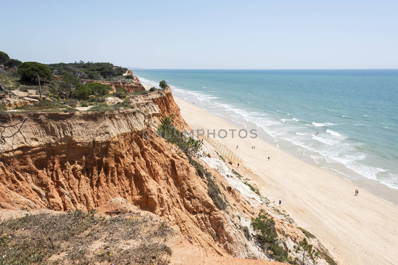 Cliffs at Praia da Falesia near villamoura in portugal area algarve with people walking at the beach