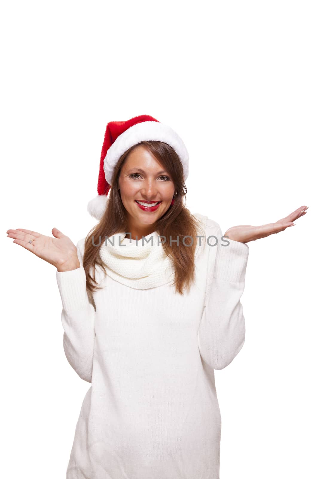Attractive woman wearing a festive red Santa hat snuggling into her warm winter polo-neck sweater with a charming friendly smile, isolated on white