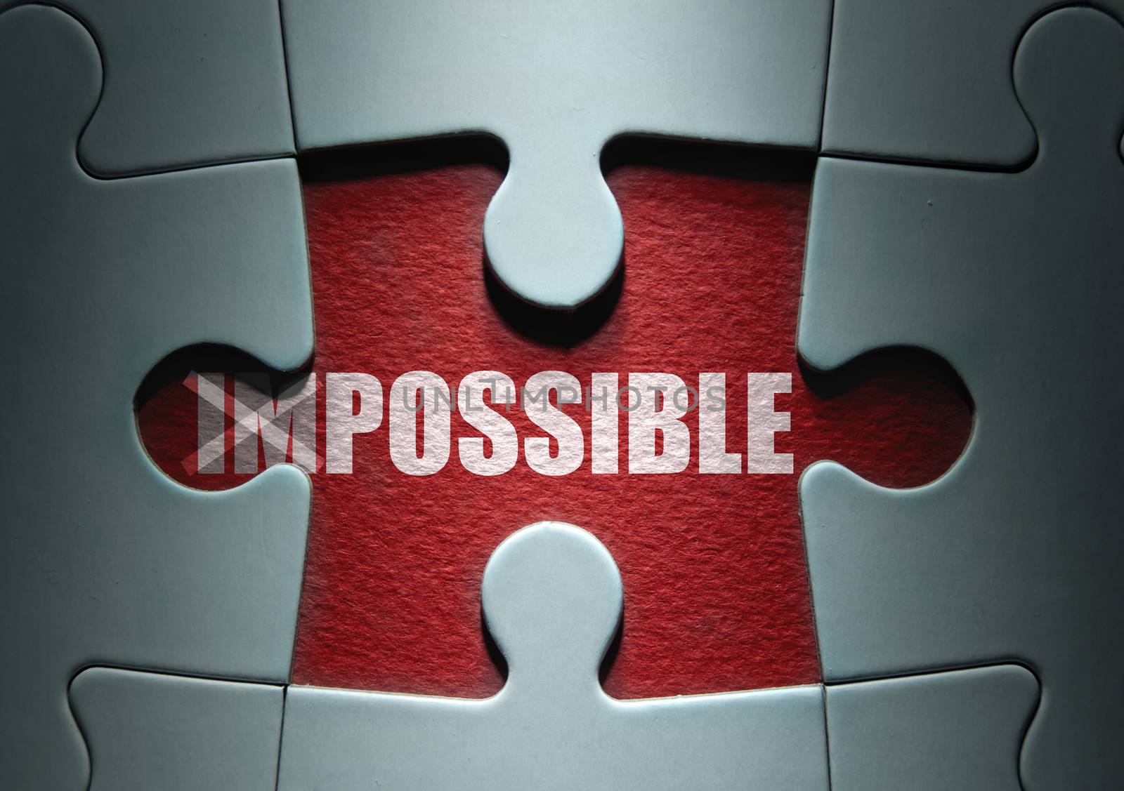Uncovered missing piece from a jigsaw puzzle revealing the word possible with impossible crossed out