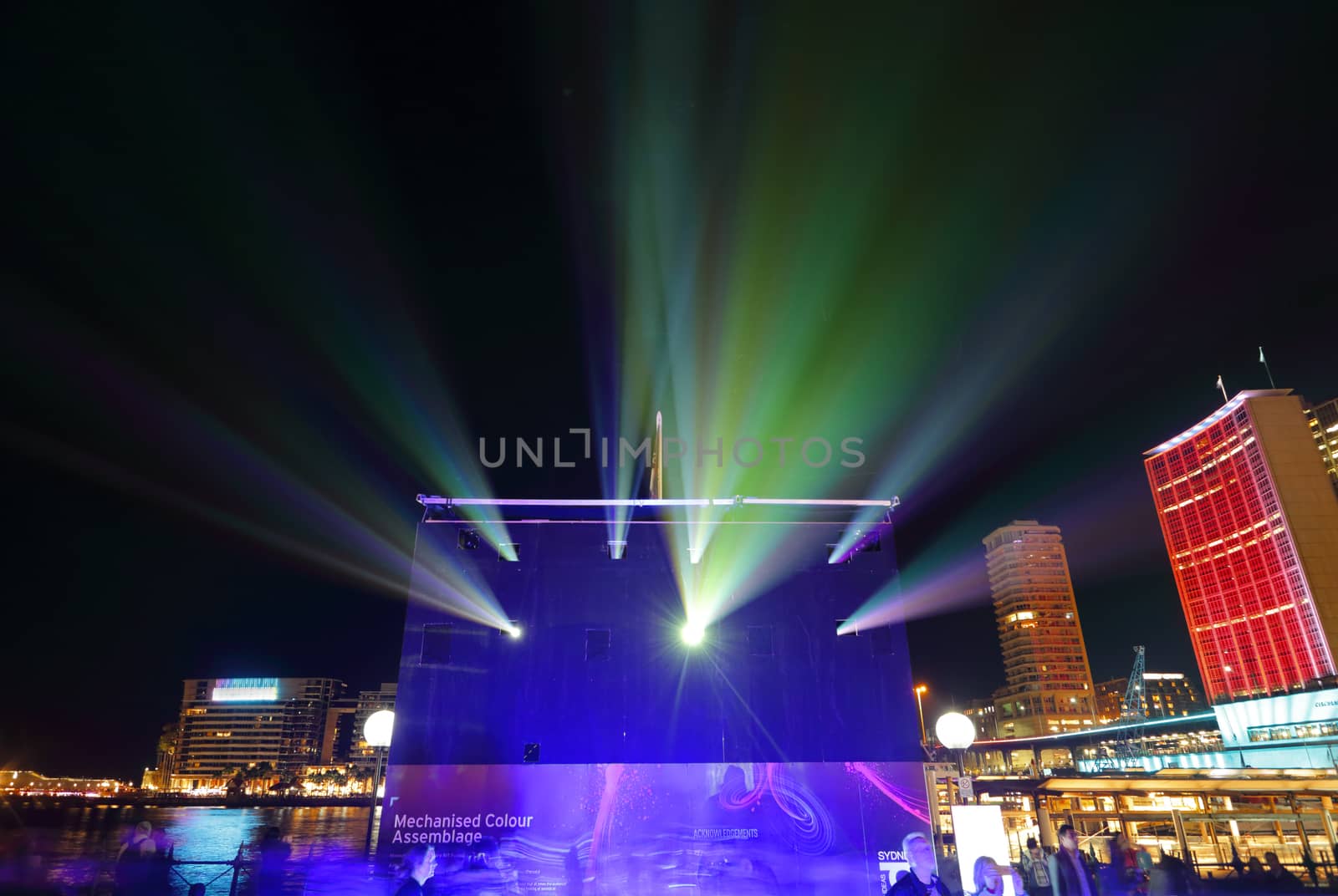 SYDNEY, AUSTRALIA - MAY 27, 2015;   Some of the projectors at Vivid Sydney.  These ones create light and effects on the Museum of Contemporary Art building, whilst surrounding buildings facades are also lit in a kaleidoscope of ever changing pretty colours.  People watch the display with fascination.