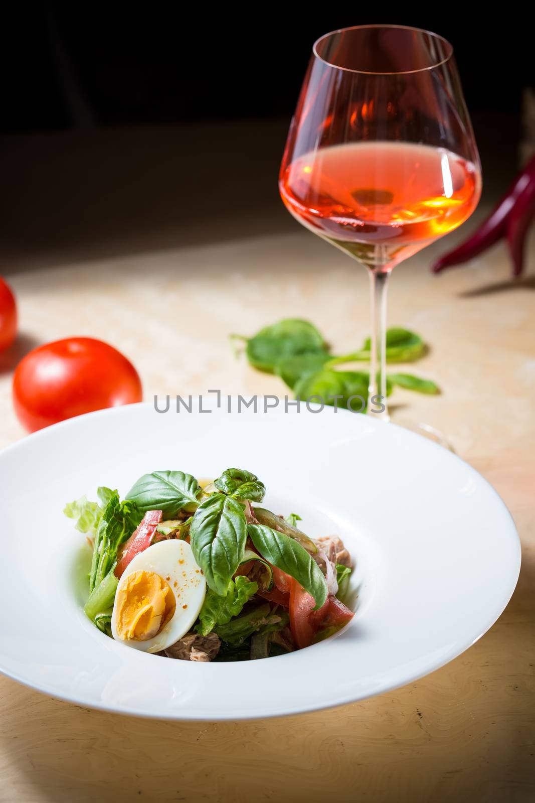 Closeup of plate of spring mix salad with strawberry, eggs and tuna