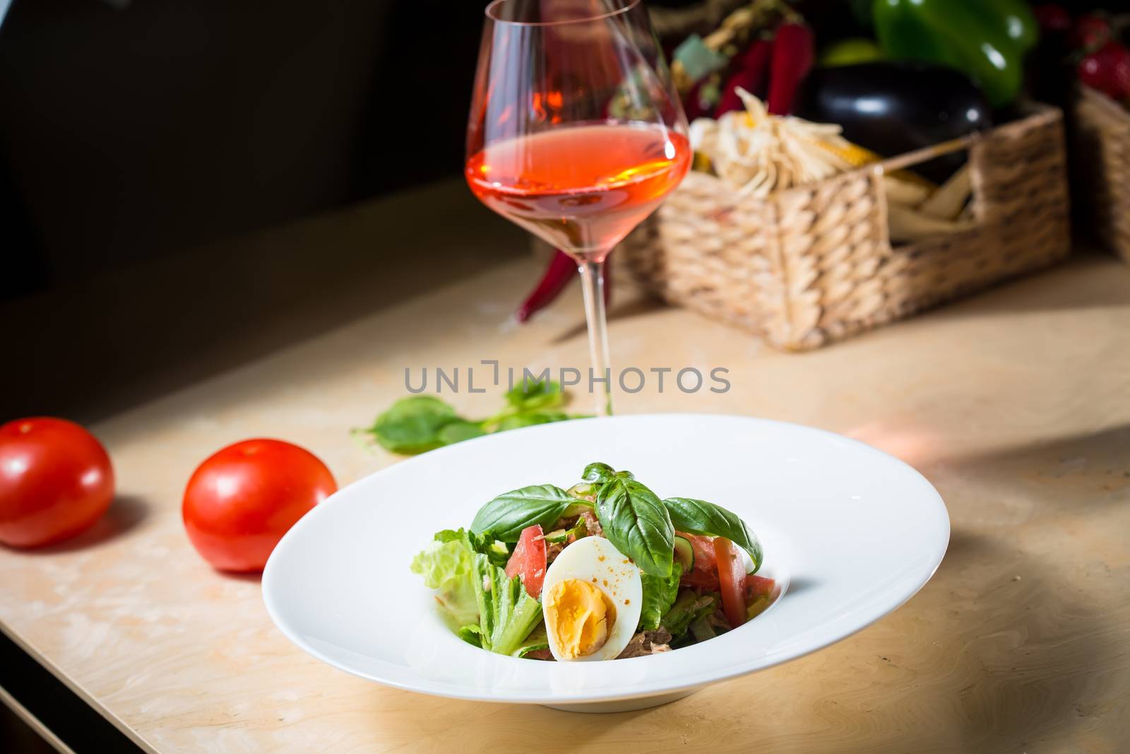 Closeup of plate of spring mix salad with strawberry, eggs and tuna