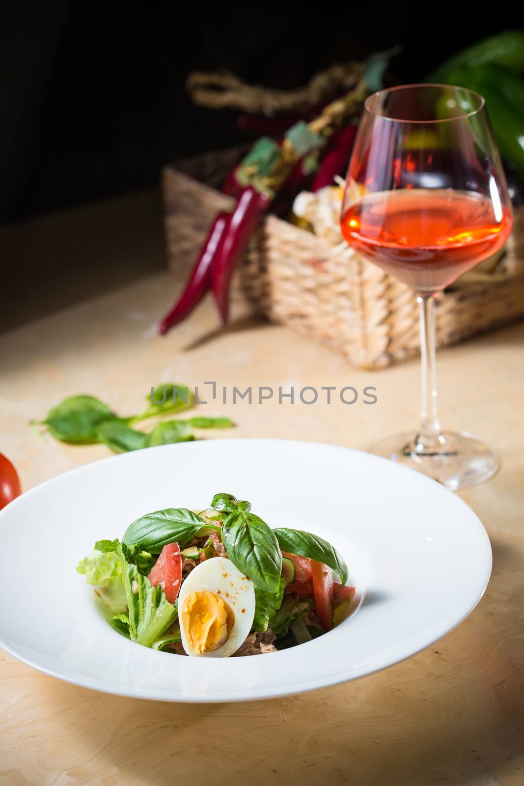 Closeup of plate of spring mix salad with strawberry, eggs and tuna