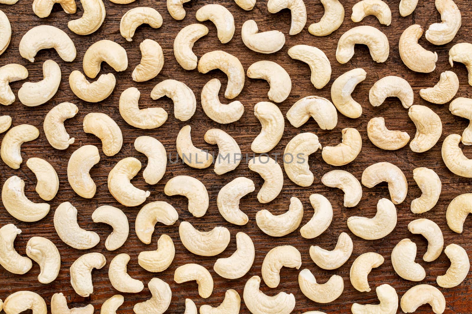 cashew nuts on rustic wood by PixelsAway