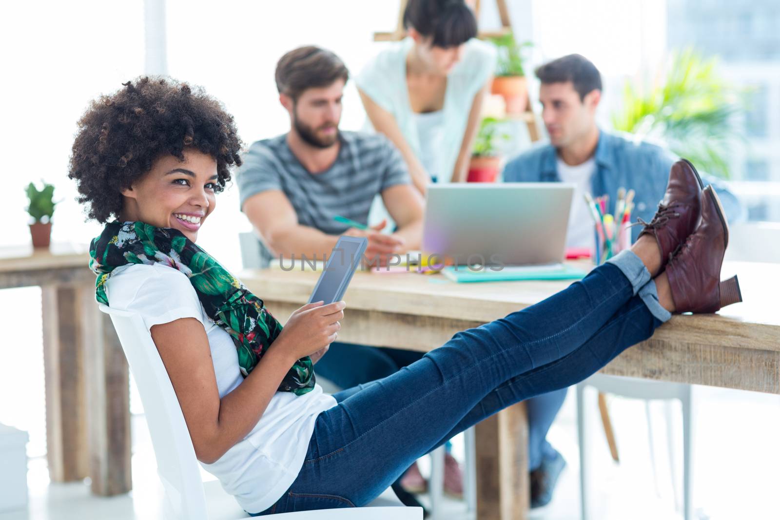 Young casual woman with feet on the table in the office