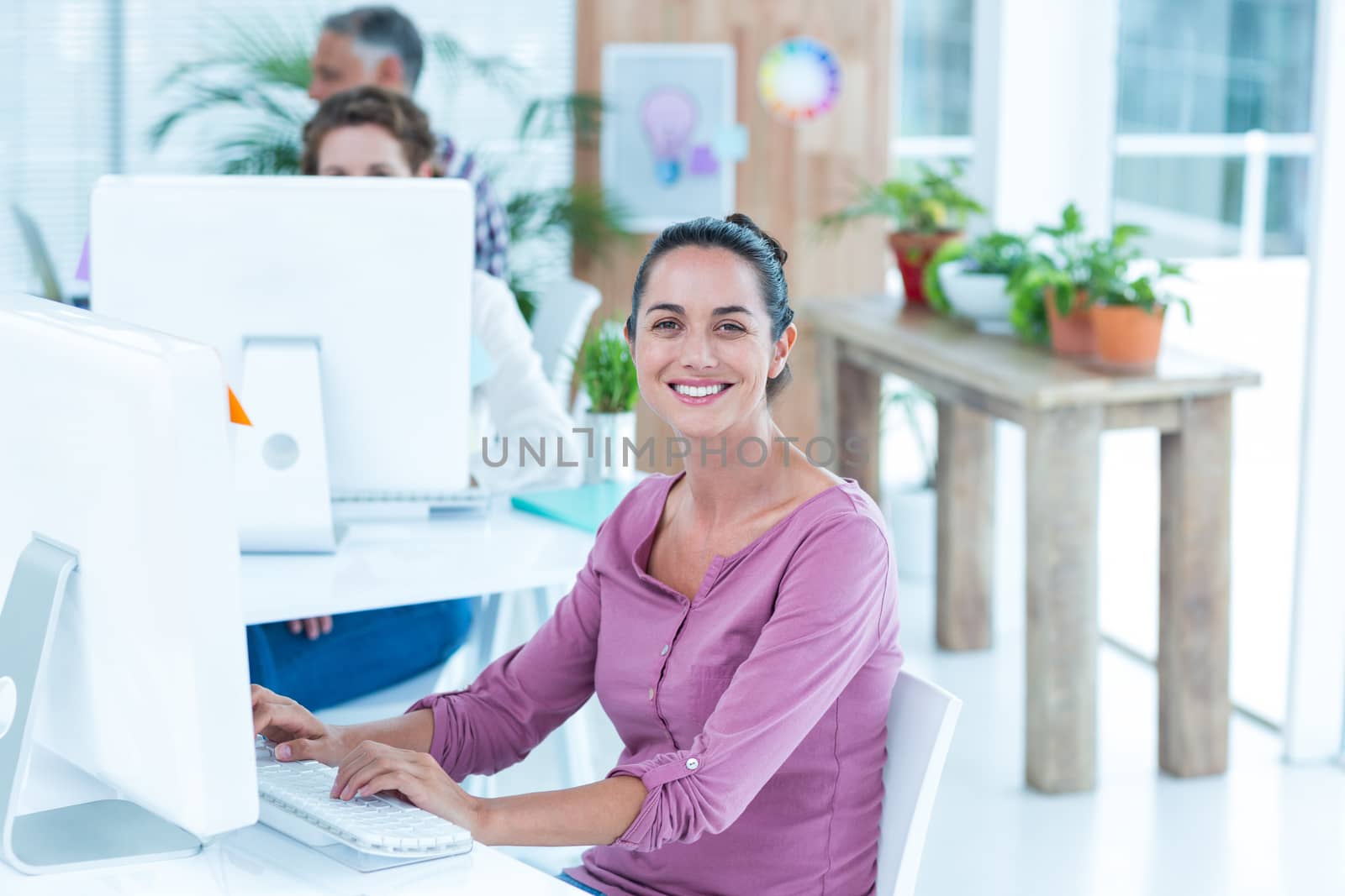 Portrait of young businesswoman using computer at office desk