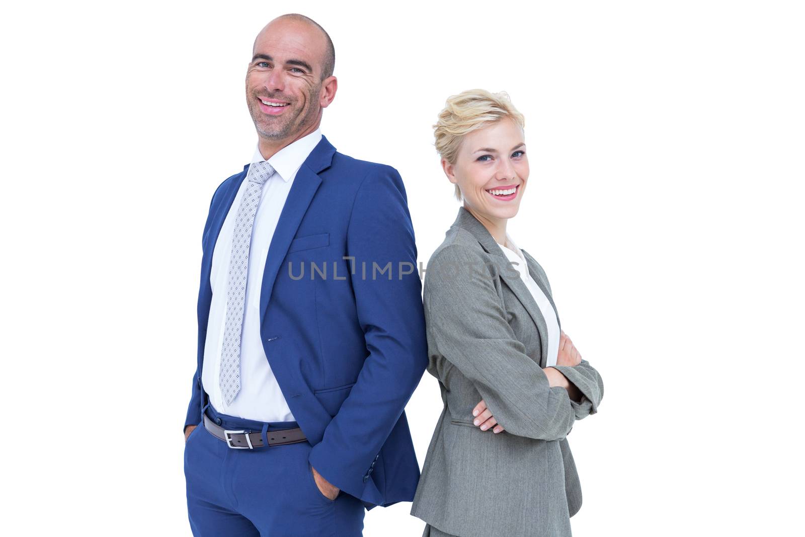 Smiling business people back-to-back with arms crossed
