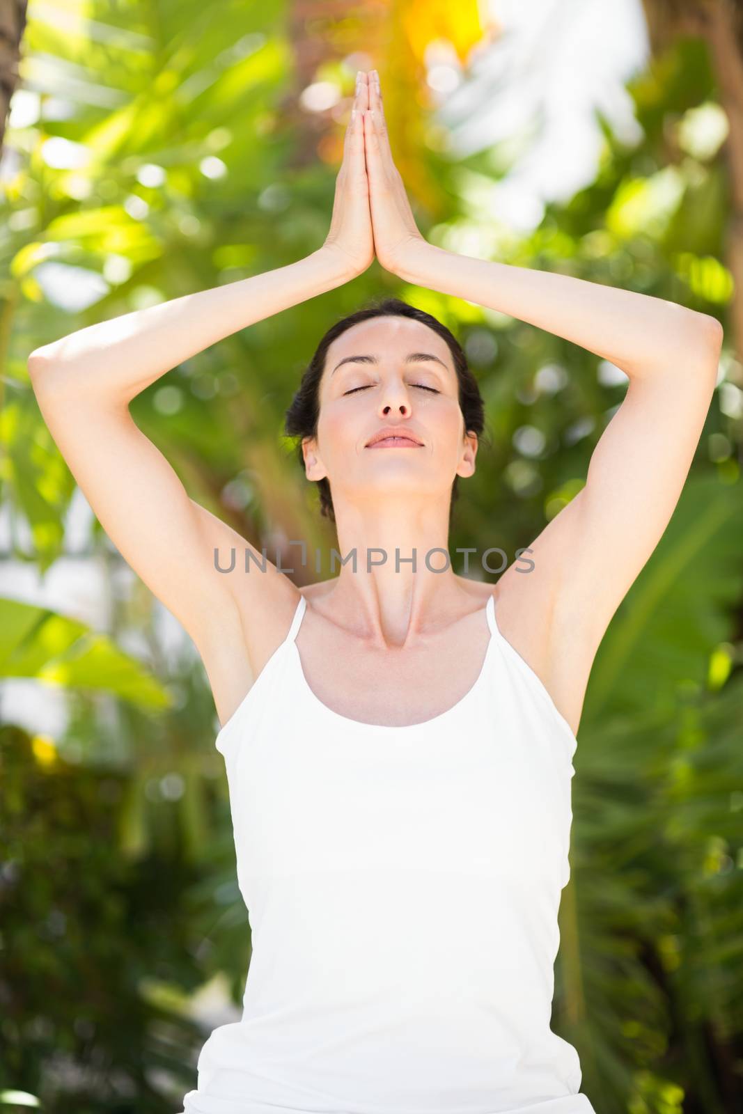 Portrait of a woman in a meditation position against a white background