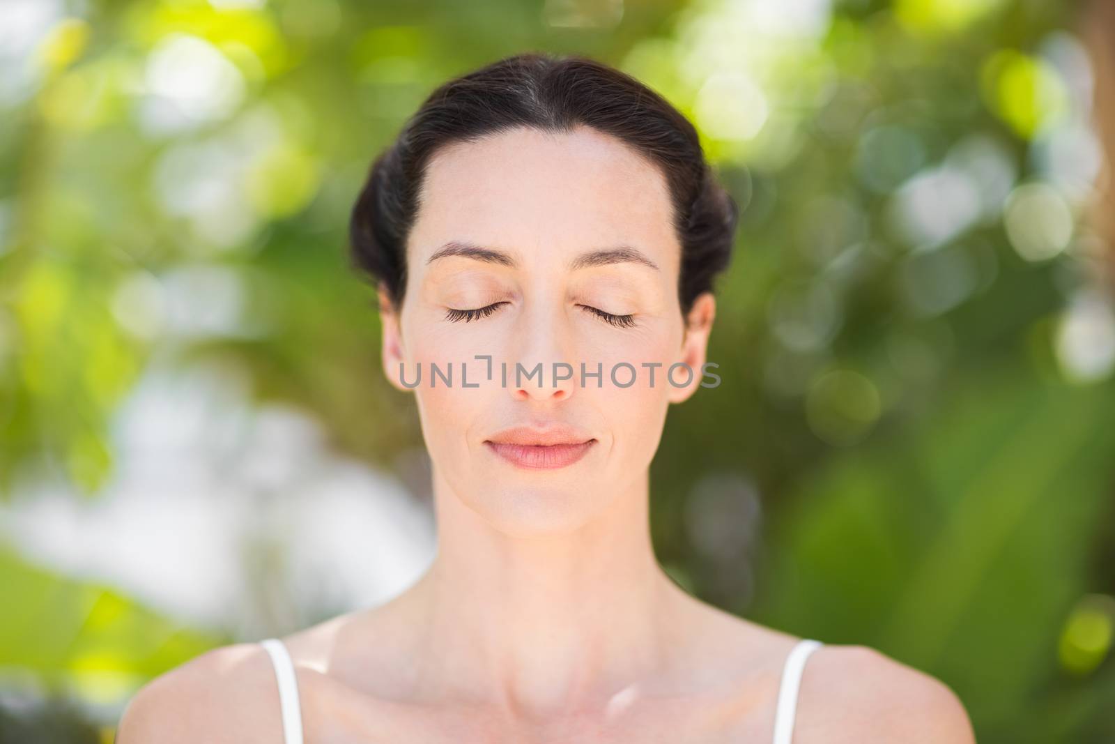 Portrait of a woman in a meditation position against a white backgrou