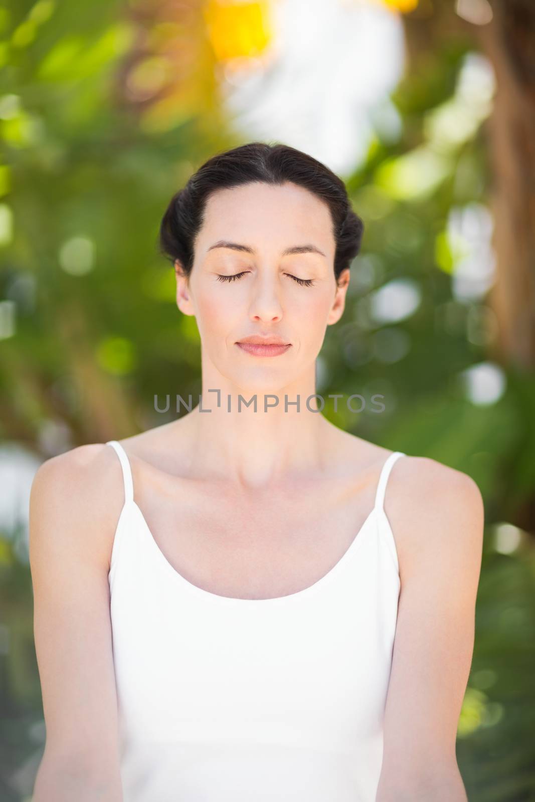 Portrait of a woman in a meditation position against a white background