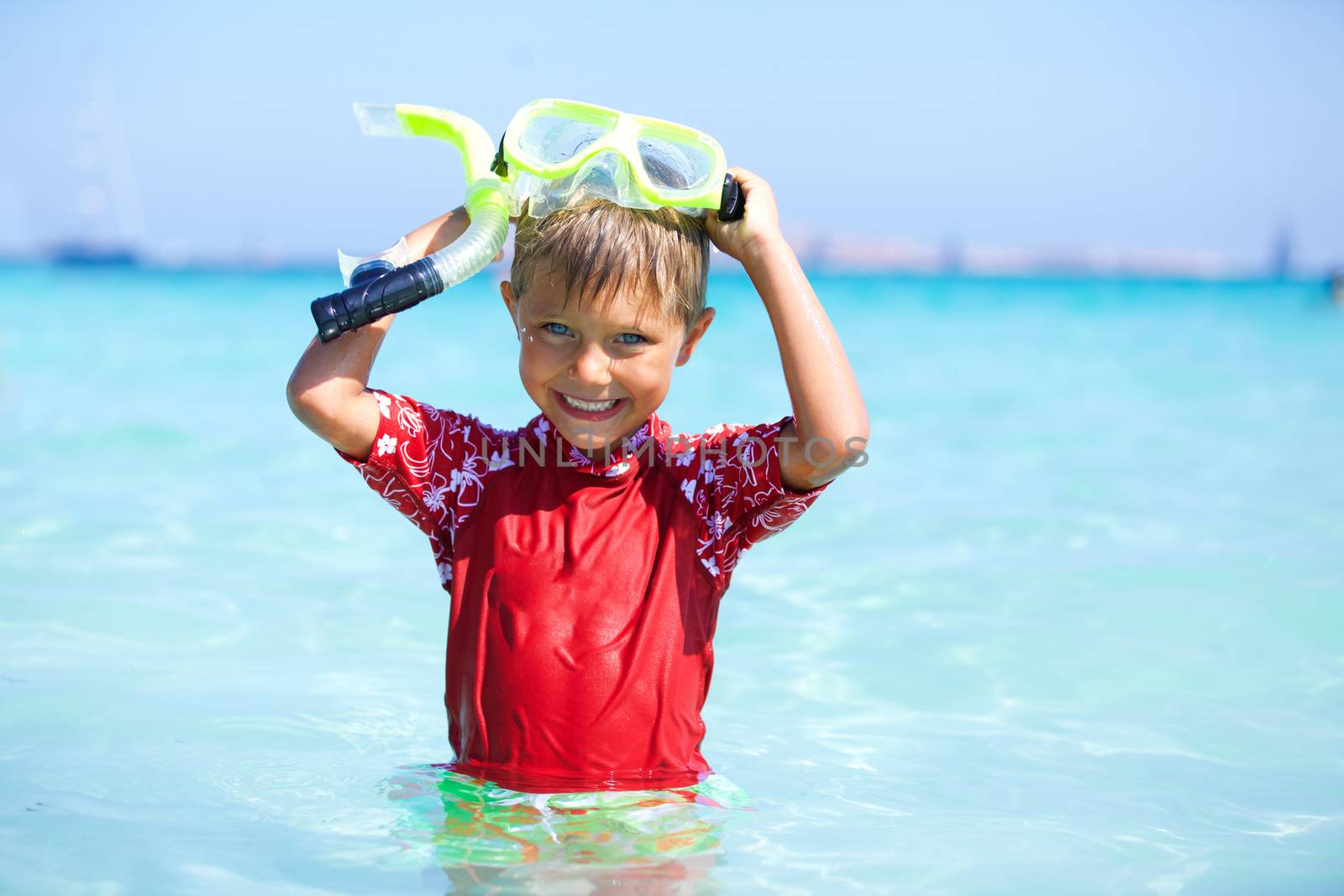 Portrait of happy cute boy wearing snorkeling mask ready to dive in the sea