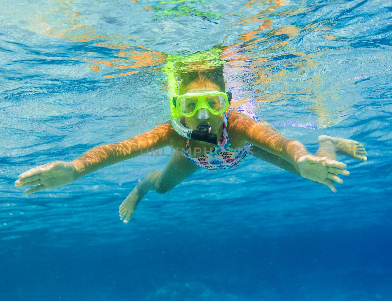 Underwater shoot of a cute girl snorkeling in a tropical sea