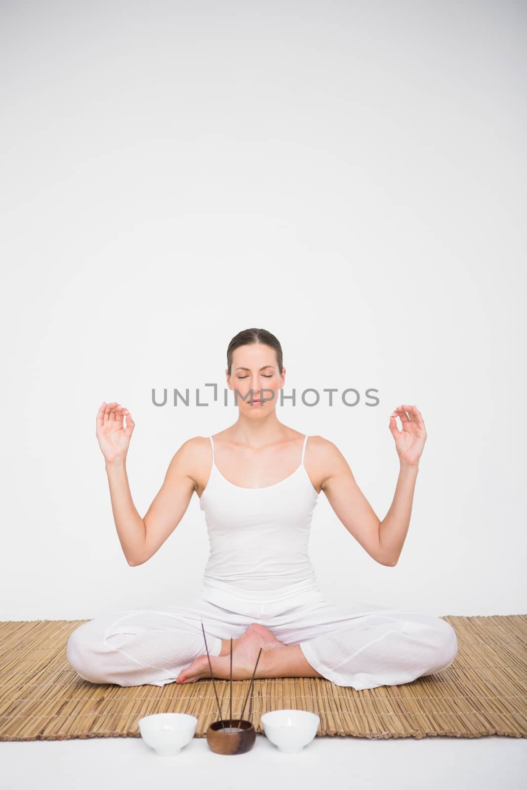 Fit woman meditating on bamboo mat by Wavebreakmedia