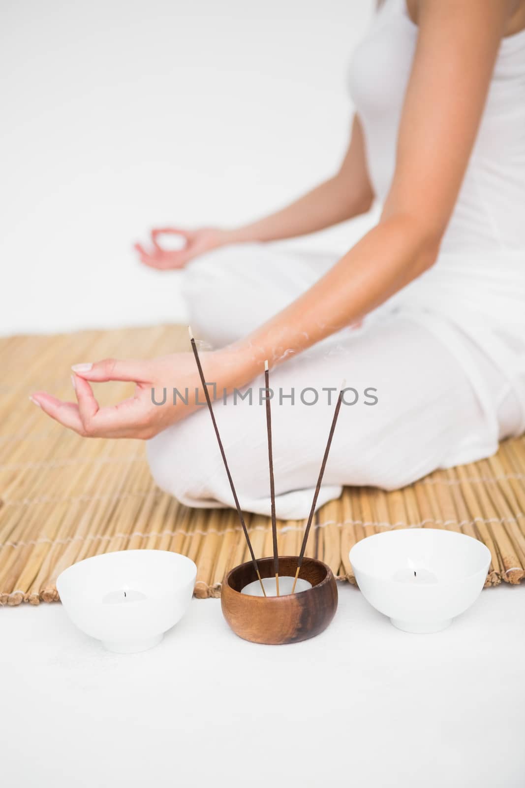 Fit woman meditating on bamboo mat by Wavebreakmedia