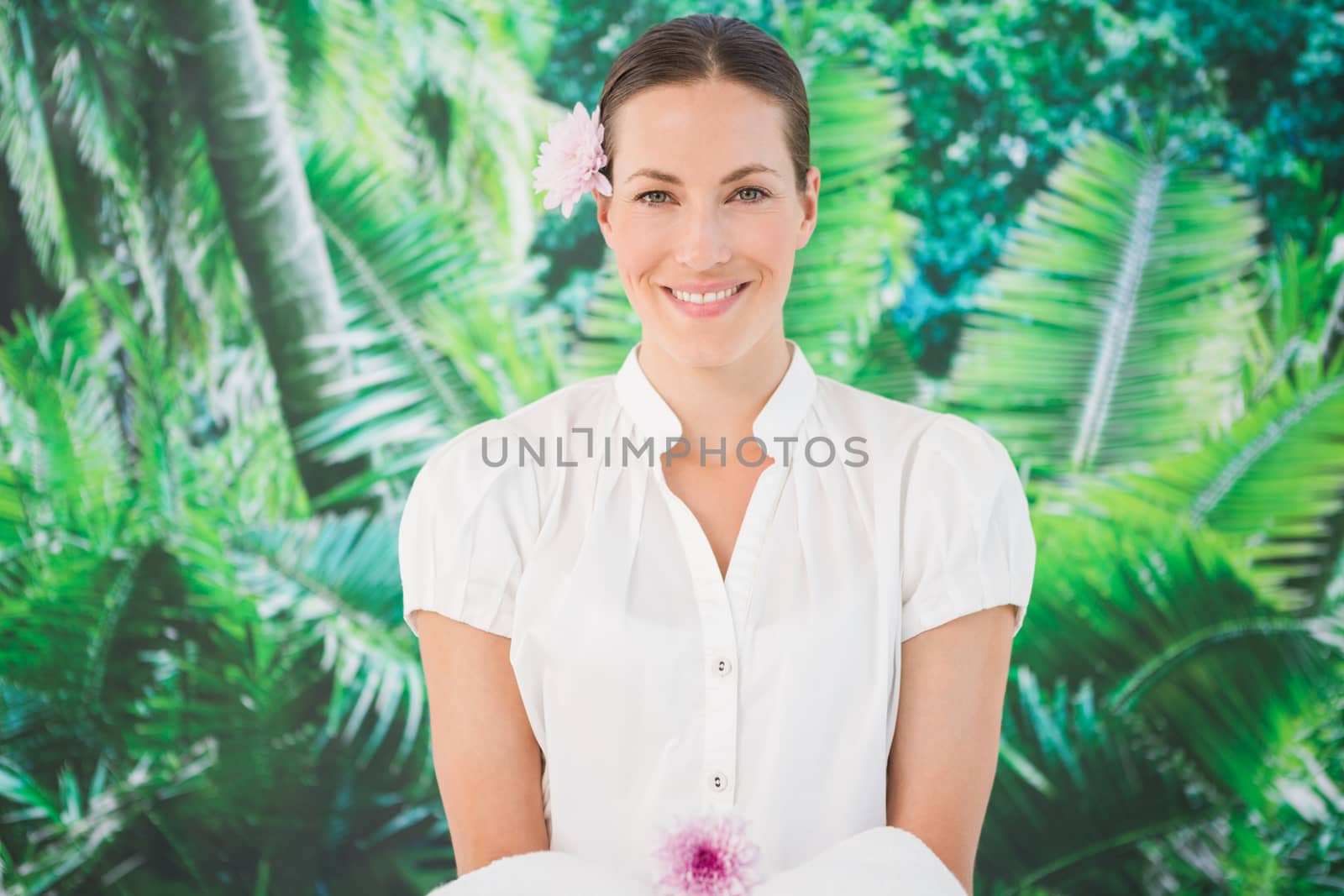 Portrait of a smiling beauty therapist holding a towel at the spa