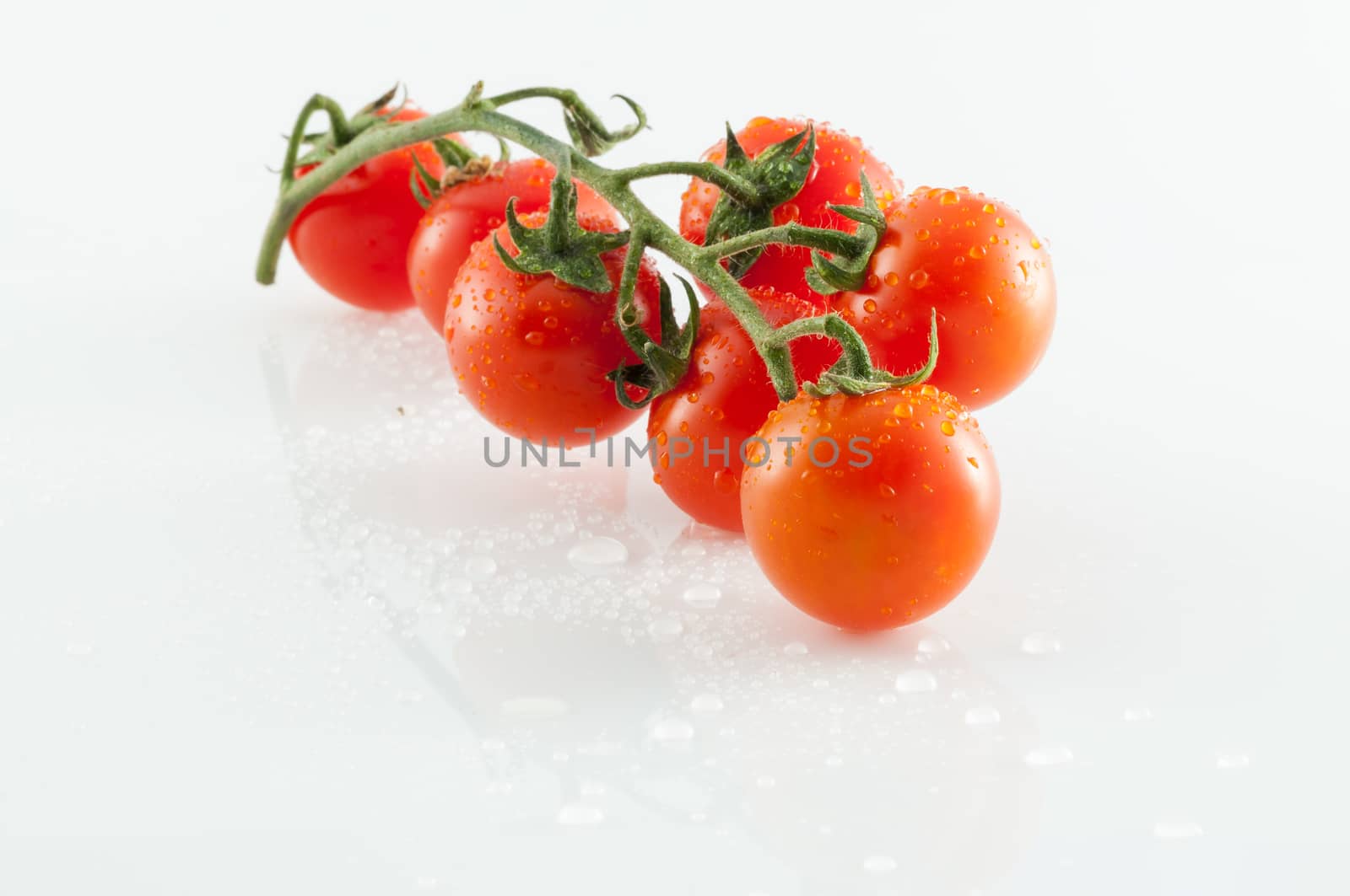 Small tomatoes on white background with reflections