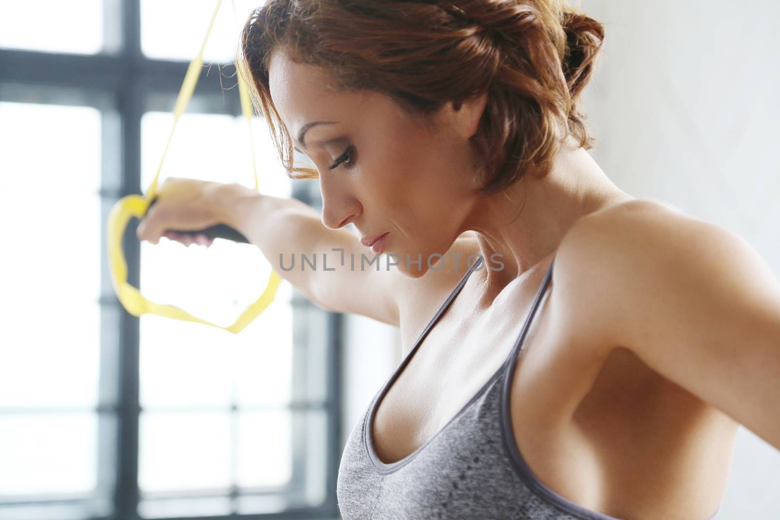 TRX. Beautiful woman at gym