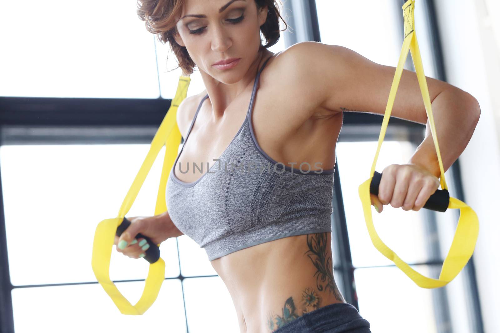 TRX. Beautiful woman at gym